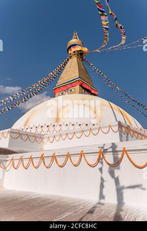 Niedriger Winkel der alten buddhistischen hemisphärischen Denkmal mit Ornament und Dekorative Augen auf Turm mit kleiner Kuppel und Girlanden auf Am Nachmittag oben unter dem Himmel Stockfoto