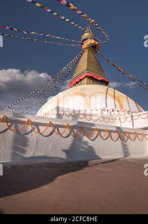 Niedriger Winkel der alten buddhistischen hemisphärischen Denkmal mit Ornament und Dekorative Augen auf Turm mit kleiner Kuppel und Girlanden auf Am Nachmittag oben unter dem Himmel Stockfoto