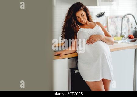Glücklich schwangere Frau stehend in der Küche Stockfoto