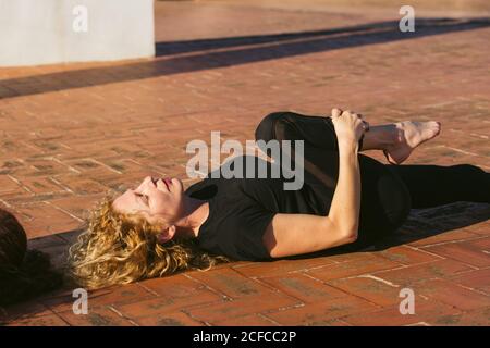 Frauen, die Yoga in Rückenlage praktizieren, posieren zusammen Stockfoto