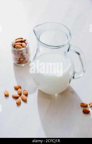 Glas Milch und Mandeln auf dem Tisch Stockfoto