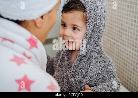 Eine Frau mit einem kleinen Kind im Bademantel, die nach dem Duschen und dem Anschauen einander nicht mehr zu erkennen war Stockfoto