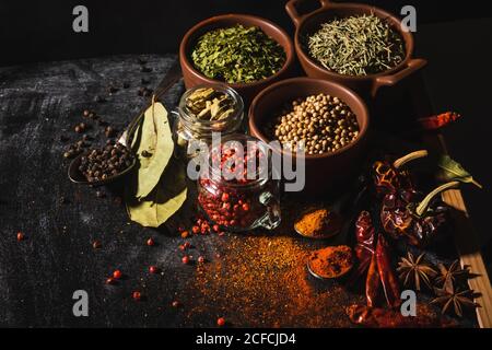 Von oben Zusammensetzung mit verschiedenen Arten von natürlichen aromatischen Gewürzen Platziert auf Schieferoberfläche Hintergrund Stockfoto