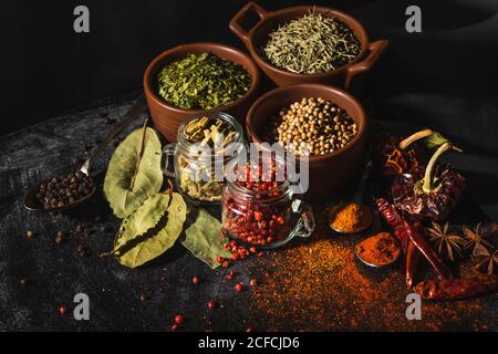 Von oben Zusammensetzung mit verschiedenen Arten von natürlichen aromatischen Gewürzen Platziert auf Schieferoberfläche Hintergrund Stockfoto