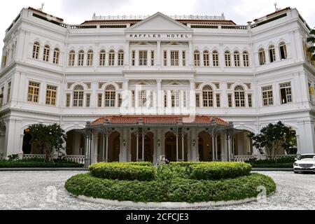 Vorderansicht des berühmten restaurierten Singapur Wahrzeichen der Ikonisches Hotel im östlichen und orientalischen Kolonialstil mit großem Schotter Auffahrt Stockfoto