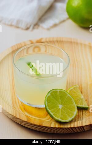 Von oben hausgemachte erfrischende Limonade im Kellner in Gläsern auf Holztablett in weißem Tischhintergrund Stockfoto
