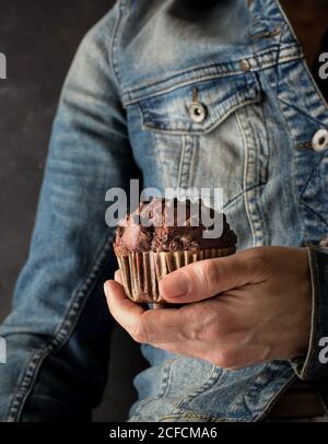 Nicht erkennbare Frau hält köstliche Schokolade Banane Muffin in der Hand in der Nähe Kamera Stockfoto