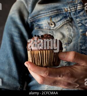 Nicht erkennbare Frau hält köstliche Schokolade Banane Muffin in der Hand in der Nähe Kamera Stockfoto