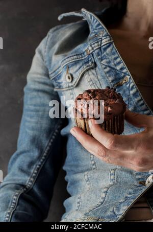 Nicht erkennbare Frau hält köstliche Schokolade Banane Muffin in der Hand in der Nähe Kamera Stockfoto