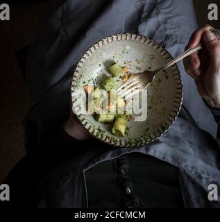 Anonyme Frau mit einer Schüssel schmackhafter Pastapaccheri mit frischem Grünkohl-Pesto und gemahlenen Erdnüssen Stockfoto