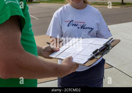 Clinton Township, Michigan, USA. September 2020. Menschen im Macomb County in Michigan unterzeichnen Petitionen, die darauf abzielen, den Notstromakt aufzuheben, den Gouverneur Gretchen Whitmer verwendet hat, um Geschäfte zu schließen und während der Coronavirus-Pandemie das Tragen von Masken zu verlangen. Die Kampagne „Unlock Michigan“ wird von prominenten republikanischen Führern unterstützt. Kredit: Jim West/Alamy Live Nachrichten Stockfoto