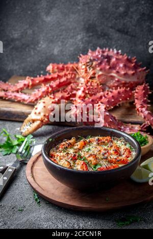 Chilenische Küche. Gebackenes Krabbenfleisch mit Käse, Sahne und Brot. Pastell o chupe de sentolla oder Königskrabbe Stockfoto