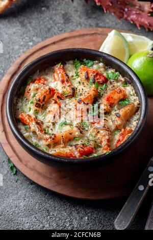 Chilenische Küche. Gebackenes Krabbenfleisch mit Käse, Sahne und Brot. Pastell o chupe de sentolla oder Königskrabbe Stockfoto