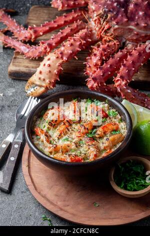 Chilenische Küche. Gebackenes Krabbenfleisch mit Käse, Sahne und Brot. Pastell o chupe de sentolla oder Königskrabbe Stockfoto