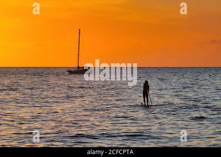 Silhouetted Stand up Paddlebarder in Lahaina Hafen bei Sonnenuntergang. Stockfoto