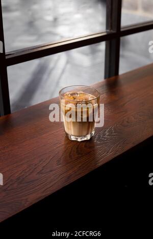 Von oben Tasse frischen kalten Eiskaffee serviert auf Holztisch im Café Stockfoto