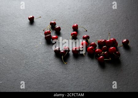 Glänzende reife rote Kirschen auf schwarzem Hintergrund Stockfoto
