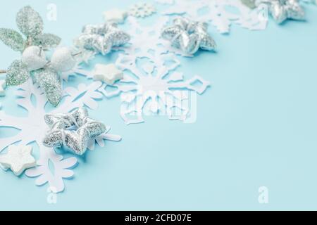 Weihnachten oder Winter Komposition. Rahmen aus papiergeschnittenen Schneeflocken und silbernen Sternen auf pastellblauem Hintergrund. Weihnachten, Winter, Neujahr Konzept. F Stockfoto