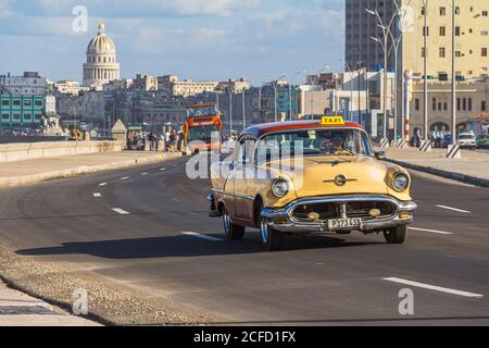 Gelbes Oldtimer als Taxi auf der Malecon - Promenade am Wasser. Das Alte Havanna, Kuba Stockfoto