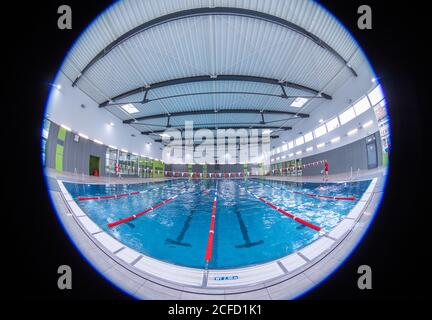 Wismar, Deutschland. September 2020. Nur wenige Schwimmer sind im großen Pool des Hallenbades auf den separaten Bahnen. (Aufgenommen mit einem extrem Weitwinkelobjektiv). Aufgrund der Schließung, die durch die Corona-Schutzmaßnahmen verursacht wurde, werden die Hallenbäder im Bundesland 2020 einen deutlichen Besucherrückgang verzeichnen. Quelle: Jens Büttner/dpa-Zentralbild/dpa/Alamy Live News Stockfoto