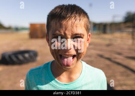 Porträt eines Jungen mit der Zunge an einem Stiefel Lager Stockfoto