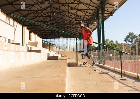 Männlicher Athlet mit Beinprothese, der die Treppe hinauf geht Stockfoto