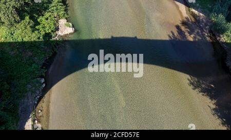 Schatten der Pont du Diable über dem Tech River bei Céret. Die Brücke wurde im 14. Jahrhundert erbaut und ihr einziger Bogen ist 45 Meter breit. Stockfoto