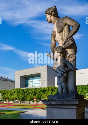 Skulptur von Ottavio Mosto aus der griechischen Mythologie, Venus mit Amor, Mirabellgarten mit Universität Mozarteum, Salzburg, Österreich Stockfoto