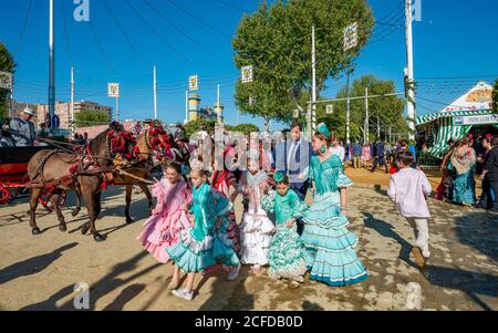 Spanische Familie mit bunten Flamenco-Kleidern vor Festzelten, Casetas, Feria de Abril, Sevilla, Andalusien, Spanien Stockfoto