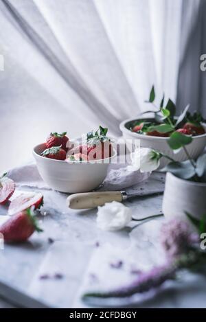 Erdbeeren und Blumen auf Marmortisch Stockfoto