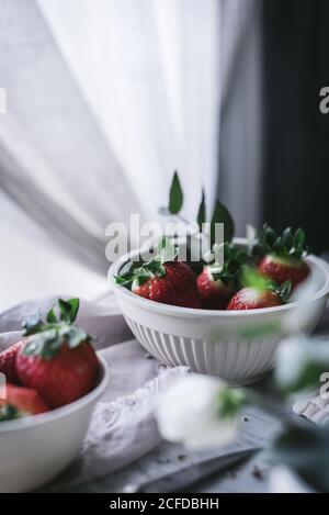 Erdbeeren und Blumen auf Marmortisch Stockfoto