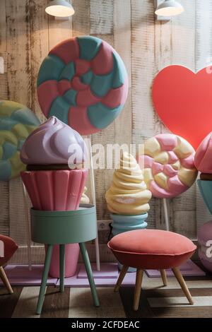 Bunte Kunststoff-Eis Kuchen und Süßigkeiten in der Nähe weich klein Stuhl im modernen Kinderzimmer Stockfoto