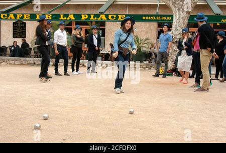 Saint-Paul-de-Vence Frankreich die Petanque-Mannschaft nach dem Wurf des Balls. Jedes Teammitglied, junge Frauen und Männer, trägt einen blauen Hut. Stockfoto