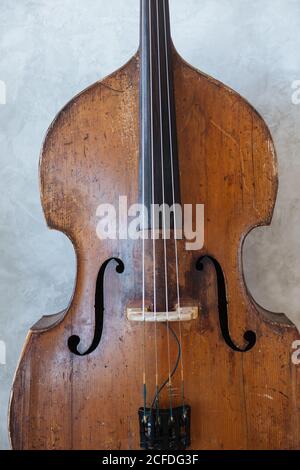 Nahaufnahme einer Holzgeige mit schwarzer Saite auf grau Oberfläche der Wand Stockfoto