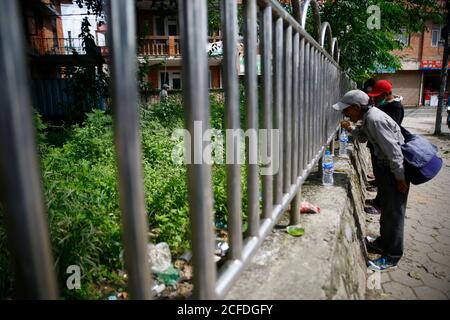 Lalitpur, Nepal. September 2020. Tägliche Wetten und Obdachlose essen kostenlose warme Mahlzeiten während der Coronavirus-Sperre, um die Ausbreitung von COVID-19 in Mahalaxmisthan in Lalitpur, Nepal am Samstag, 5. September 2020 einzudämmen. Die Hiteri-Stiftung, in der die Werke von Kusum Tamang Poudyal mehr als 2500 warme Mahlzeiten während der ersten Sperre verteilt haben, sowie Lebensmittelverpackungen im Wert von einem Monat an mehr als 2200 Familien in der Krise. Während der zweiten Sperre verteilten sie bereits rund 900 Mahlzeiten und rund 20 Lebensmittelverpackungen an Familien in der Krise, wobei etwa 65 Familien darauf warteten, diese Pakete zu erhalten. Kusum heute pro Stockfoto