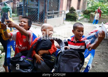 Lalitpur, Nepal. September 2020. Kinder reagieren, nachdem sie kostenlose Leckereien außerhalb ihres halb gemieteten Zimmers während der Coronavirus-Sperre erhalten haben, um die Ausbreitung von COVID-19 im Mahalaxmisthan in Lalitpur, Nepal, am Samstag, 5. September 2020 einzudämmen. Kusum Tamang Poudyal lieferte heute Schultaschen mit Heften, Bleistiften, Farben, Geschichten und Spielzeug, die vom Rotary E-Club Nepal an Kinder von Saili Tamang gespendet wurden. Eine alleinerziehende Mutter von zwei Jahren nach der Trennung von ihrem Mann, der ein Alkoholiker seit zwei Jahren war, nachdem er begann, Dinge aus dem Haus zu stehlen und zu trinken und gewalttätig zu werden Stockfoto