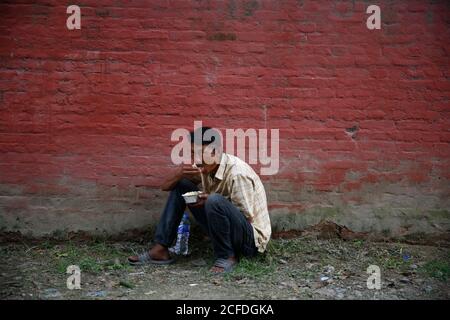 Lalitpur, Nepal. September 2020. Tägliche Wetten und Obdachlose essen kostenlose warme Mahlzeiten während der Coronavirus-Sperre, um die Ausbreitung von COVID-19 in Mahalaxmisthan in Lalitpur, Nepal am Samstag, 5. September 2020 einzudämmen. Die Hiteri-Stiftung, in der die Werke von Kusum Tamang Poudyal mehr als 2500 warme Mahlzeiten während der ersten Sperre verteilt haben, sowie Lebensmittelverpackungen im Wert von einem Monat an mehr als 2200 Familien in der Krise. Während der zweiten Sperre verteilten sie bereits rund 900 Mahlzeiten und rund 20 Lebensmittelverpackungen an Familien in der Krise, wobei etwa 65 Familien darauf warteten, diese Pakete zu erhalten. Kusum heute pro Stockfoto
