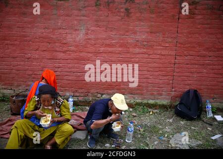 Lalitpur, Nepal. September 2020. Tägliche Wetten und Obdachlose essen kostenlose warme Mahlzeiten während der Coronavirus-Sperre, um die Ausbreitung von COVID-19 in Mahalaxmisthan in Lalitpur, Nepal am Samstag, 5. September 2020 einzudämmen. Die Hiteri-Stiftung, in der die Werke von Kusum Tamang Poudyal mehr als 2500 warme Mahlzeiten während der ersten Sperre verteilt haben, sowie Lebensmittelverpackungen im Wert von einem Monat an mehr als 2200 Familien in der Krise. Während der zweiten Sperre verteilten sie bereits rund 900 Mahlzeiten und rund 20 Lebensmittelverpackungen an Familien in der Krise, wobei etwa 65 Familien darauf warteten, diese Pakete zu erhalten. Kusum heute pro Stockfoto