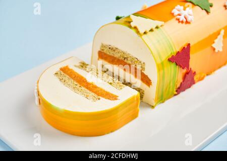 Nahaufnahme schneiden köstliche Obstkuchen mit Weihnachtsbäumen und geschmückt Auf blauem Hintergrund an Bord platziert Stockfoto