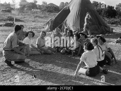 Originalunterschrift: Die Vintage-Saison Zikh'ron Ya'aqov Juli 24 1939. Arbeiter im Lager sitzen in einem Ring Storytelling - Ort: Israel--Zikhron YaÊ»aá¸³ov ca. 1939 Stockfoto