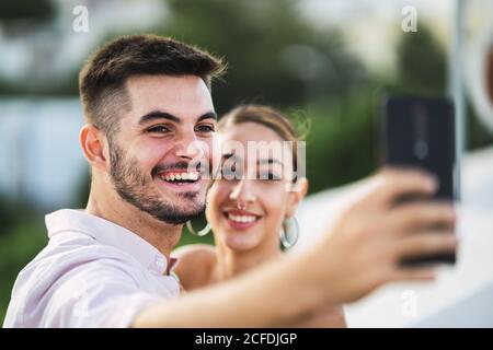 Junge kaukasische Paar nimmt ein Selfie, während im stehen Balkon Stockfoto