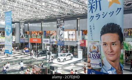 Sapporo, Hokkaido, Japan - Inland Terminal Atrium des New Chitose Airport. Werbung hängende Banner über Sapporo Beer und Nippon-Ham Fighters. Stockfoto