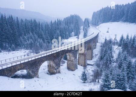 Alte schneebedeckte Eisenbahnbrücke in der Ukraine Stockfoto