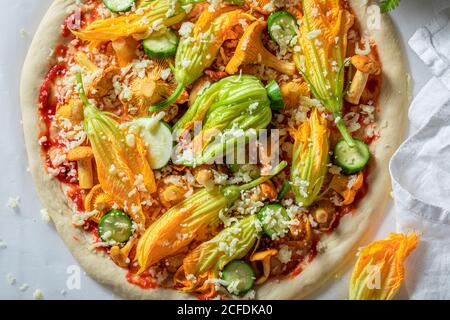 Zutaten für vegetarische Pizza mit Pfifferlingen, Zucchini und Mozzarella auf Backpapier Stockfoto