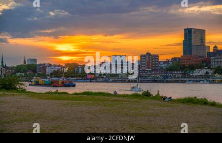 Deutschland, Hamburg, Abendstimmung auf der Norderelbe, Blick von HH-Steinwerder auf die St. Pauli Landungsbrücken, auf der Elbe ein Segelboot, und ein Stockfoto