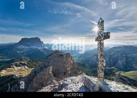 Grödner Pass, Provinz Bozen, Südtirol, Italien. Das Gipfelkreuz der Großen Cirspitze. Im Hintergrund der Langkofel und das Grödnertal Stockfoto