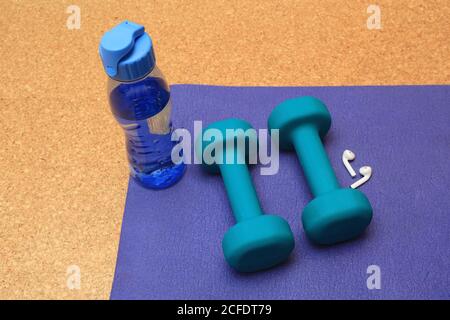 , - 01. Jan 1970: Fitness, zwei Kurzhanteln, Flaschenwasser und bluetooth-Kopfhörer, zu Hause Stockfoto