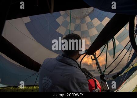 Deutschland, Sachsen-Anhalt, Fir, Pilot betreibt Brenner eines Heißluftballons. Stockfoto