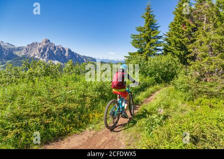 Frau mit E-Bike in der Naturlandschaft des Monte cherz, dolomiten, livinallongo del col di lana, belluno, venetien, italien Stockfoto