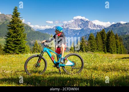 Frau mit E-Bike in der Naturlandschaft des Monte cherz, dolomiten, livinallongo del col di lana, belluno, venetien, italien Stockfoto